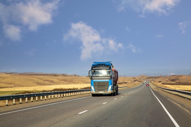 De vrachtwagen rijdt langs een snelweg in de voorsteden Logistiek voor vrachtvervoer