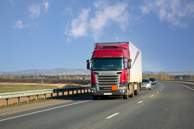 De vrachtwagen rijdt langs een snelweg in de voorsteden Logistiek voor vrachtvervoer