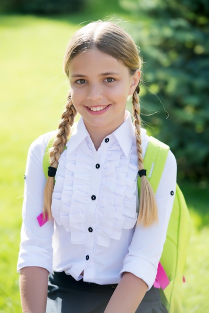 Foto de vreugde delen. gelukkig kind glimlach zonnig buitenshuis. terug naar school blik van meisje kind. formeel uniform. schoolmode. jeugd onderwijs. kinderdag.