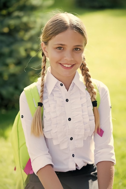 Foto de vreugde delen gelukkig kind glimlach zonnig buitenshuis terug naar school blik van meisje kind formeel uniform schoolmode jeugdeducatie kinderdag