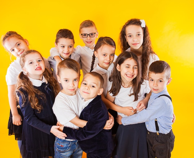 De vriendelijke klasgenoten knuffelen op een gele achtergrond