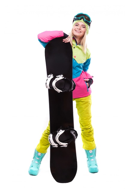 De vrij jonge vrouw in skiuitrusting houdt snowboard