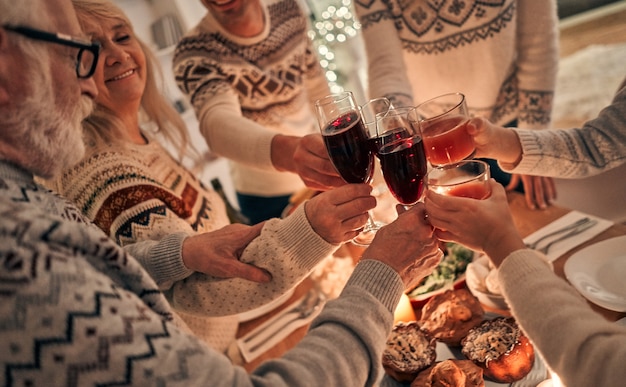 De vrolijke familie rammelglazen boven de kersttafel