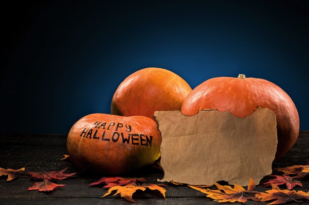 De vrolijke Halloween-pompoenen op houten tafel