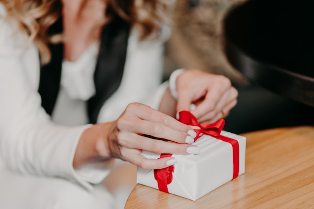 De vrouw bindt huidig met rood lint