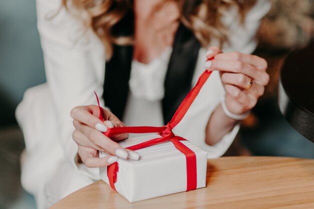 De vrouw bindt huidig met rood lint