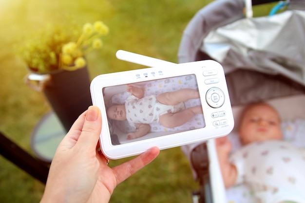 Foto de vrouw controleert de babyfoon voor de veiligheid van de baby