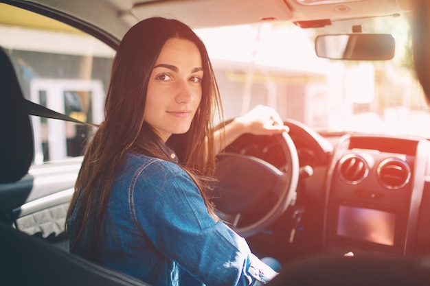 De vrouw die de auto glimlachen glimlachen