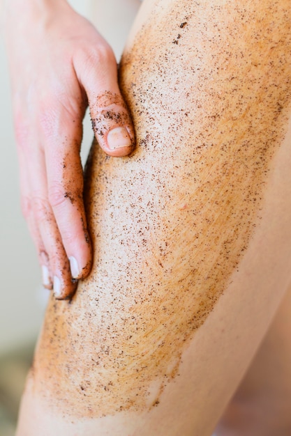 Foto de vrouw die lichaam toepast schrobt op haar been