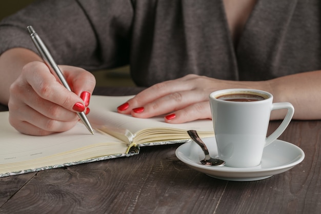 De vrouw doet planning en drinkt koffie