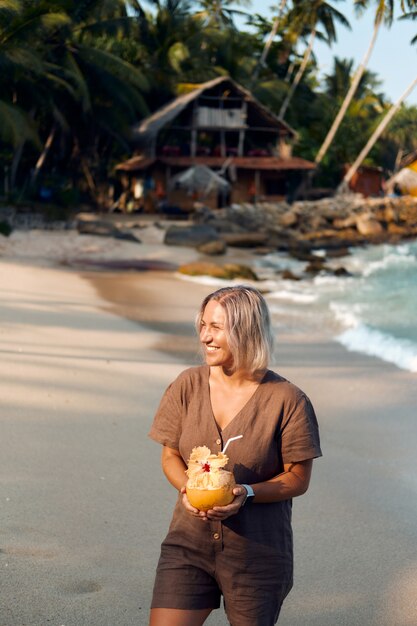 De vrouw drinkt Kokossap bij Tropisch Strand