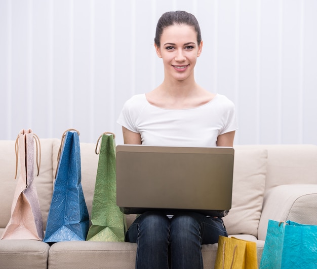 De vrouw gebruikt laptop terwijl het zitten op de laag.