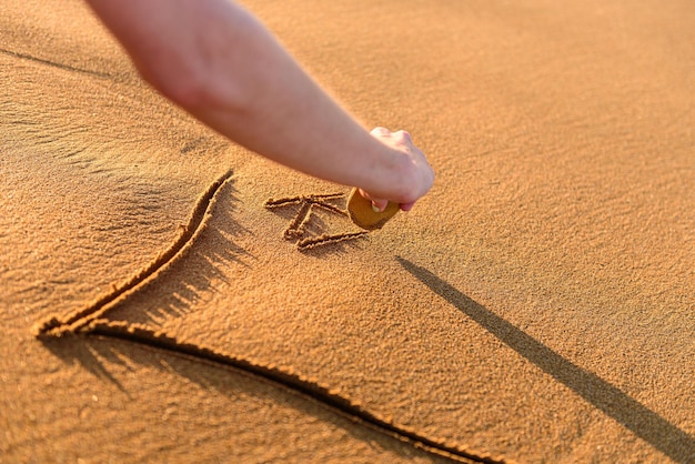 de vrouw hartvorm tekenen op zeezand Hartvorm getekend in het zand op een strand