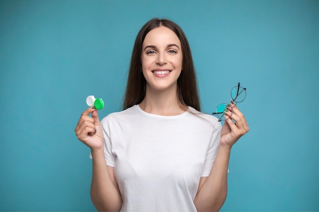 De vrouw houdt contactlenzen en glazen in handen. concept van keuze van zichtbescherming