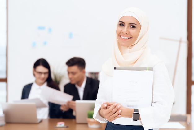 De vrouw in de hijab staat in het callcenter.