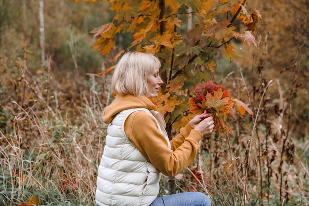 De vrouw is in het herfstpark Wandeling door het bos Herfstsfeer