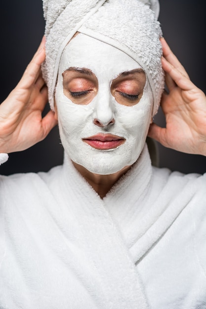 De vrouw is witte klei op zijn gezichtsmasker