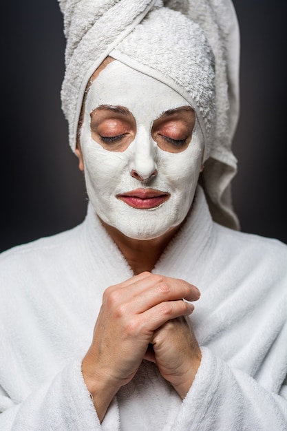 De vrouw is witte klei op zijn gezichtsmasker