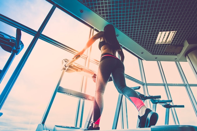 De vrouw joggen op de loopband op de achtergrond van de wolk