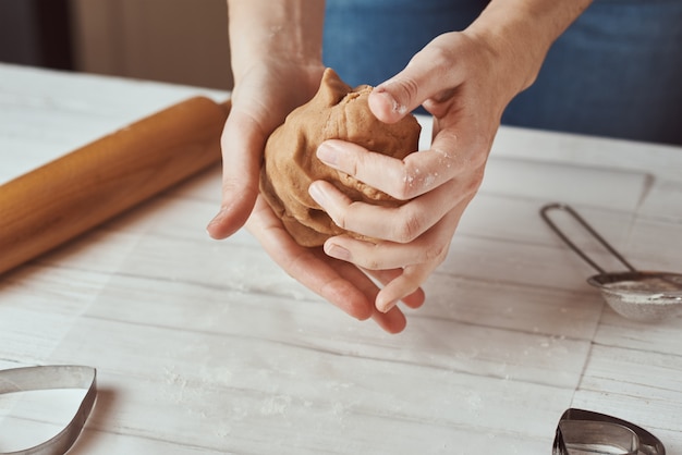 De vrouw kneedt deeg met indient keuken