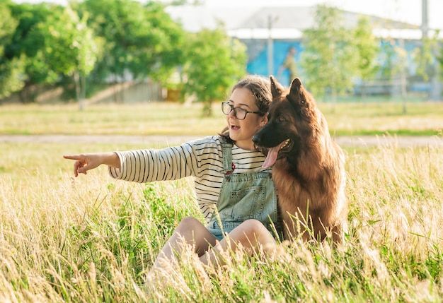 De vrouw koestert haar hondduitse herder in de herfstpark