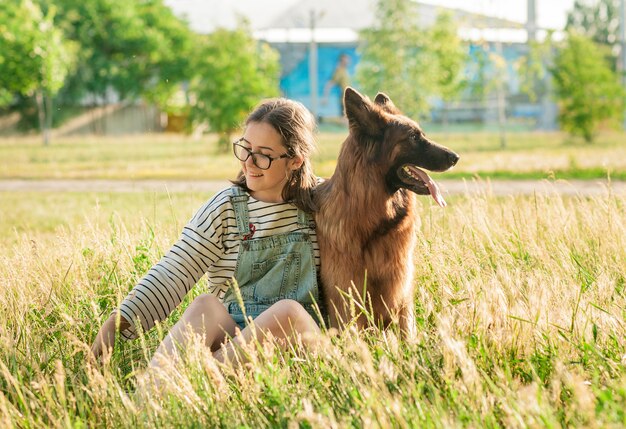 De vrouw koestert haar hondduitse herder in de herfstpark