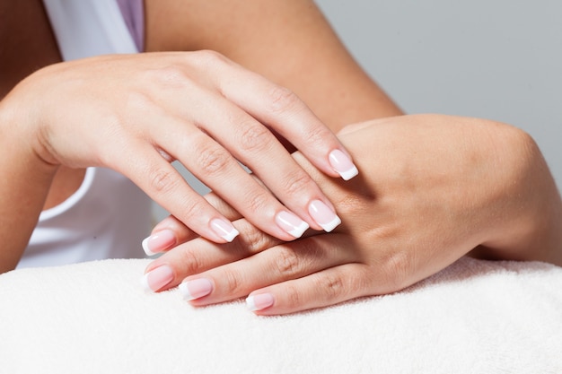 De vrouw laat een mooie Franse manicure zien die elkaar de hand geeft