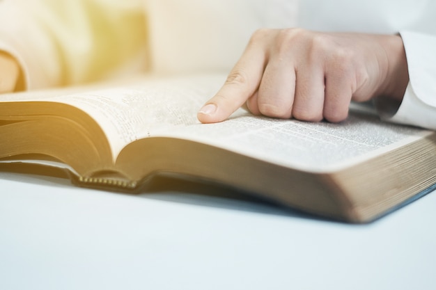 De vrouw leest de bijbel in de kamer.