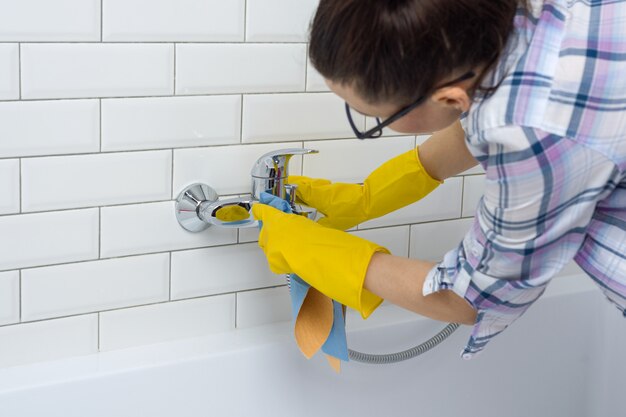 De vrouw maakt thuis in de badkamers schoon