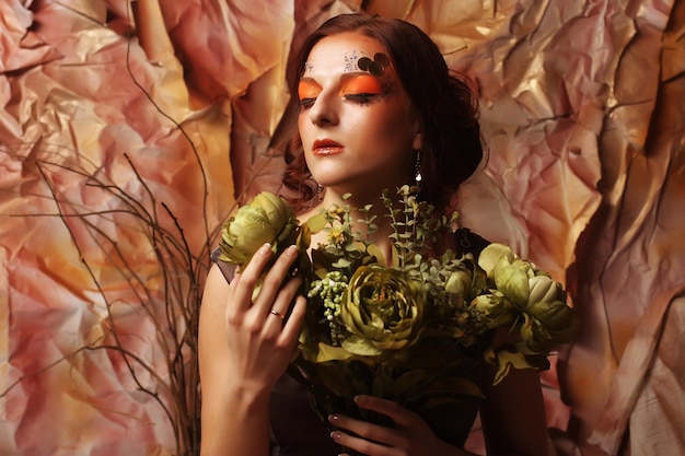 De vrouw met heldere creatief maakt omhoog het houden van groene bloemen