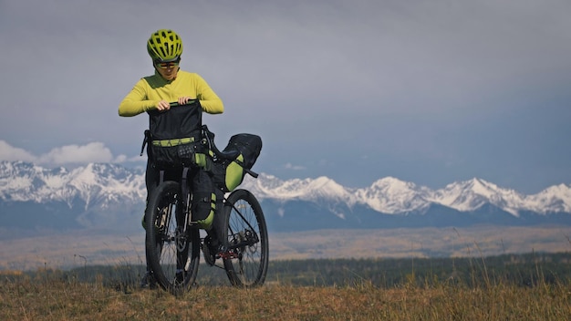 De vrouw reist op gemengd terrein fietstochten met bikepacking