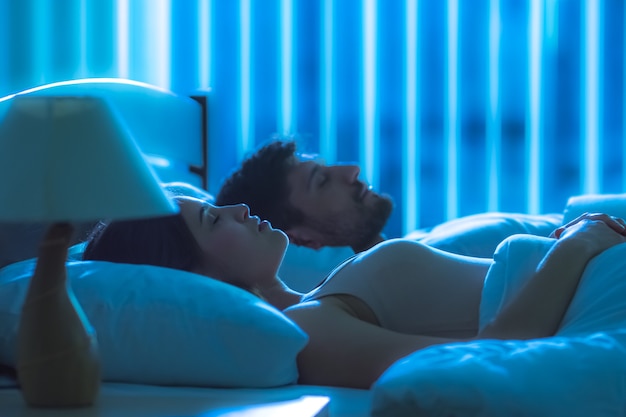 De vrouw slaapt in de buurt van de man in het bed. nachttijd