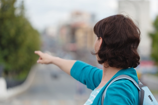 De vrouw toont de linkerkant toont wijsvingerwijsvinger