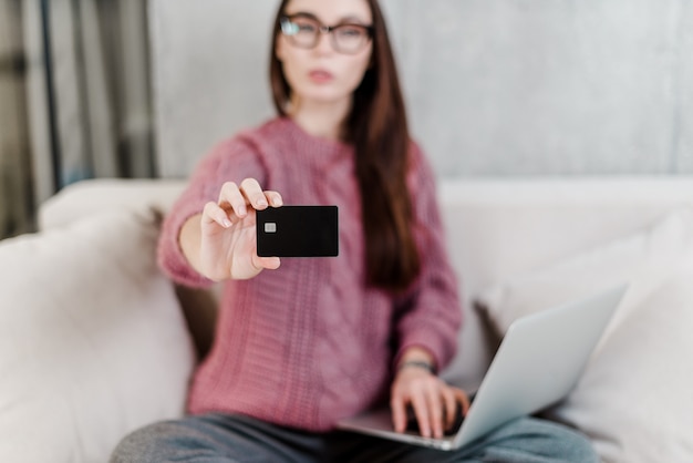 De vrouw toont thuis creditcard op bank