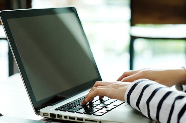 De vrouw typt in haar laptop computer.