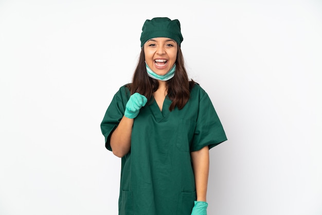 De vrouw van de chirurg in groen uniform op witte muur verraste en richtend voorzijde