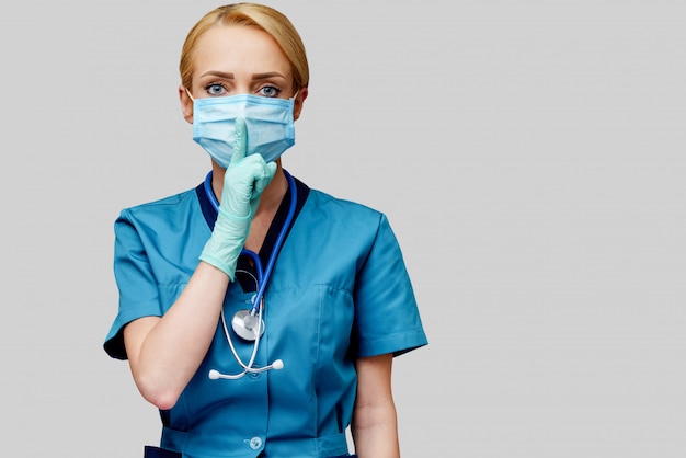 De vrouw van de medische artsenverpleegster met stethoscoop die beschermend masker en rubber of latexhandschoenen draagt