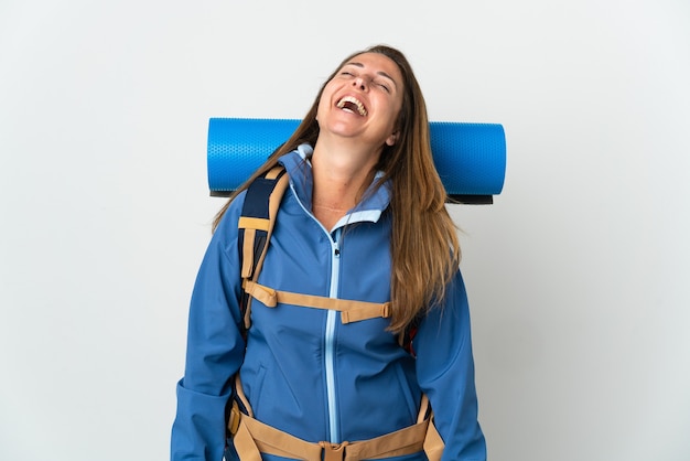 De vrouw van de middelbare leeftijdsbergbeklimmer met een grote rugzak over het geïsoleerde muur lachen