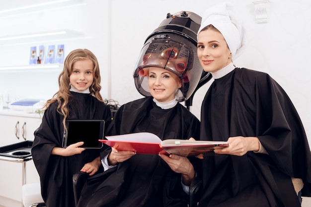 De vrouw zit in kapdroger bij schoonheidssalon.