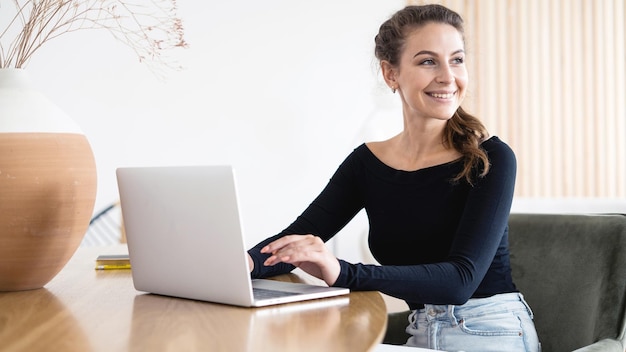 De vrouwelijke consultant glimlacht, werkt op kantoor en gebruikt een laptopcomputer