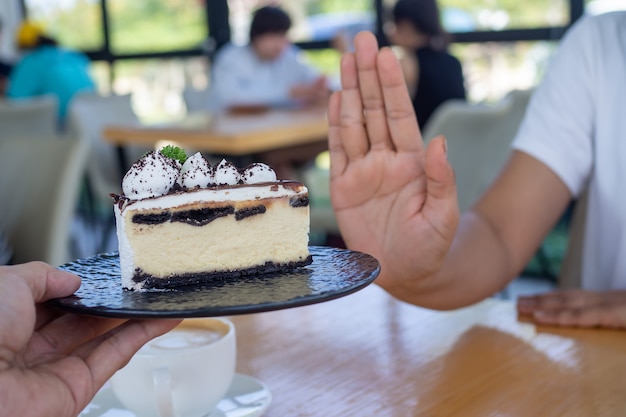 Foto de vrouwen duwden samen met de mensen het taartbord. eet geen desserts om af te vallen.