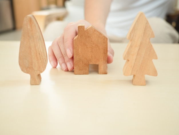 De vrouwen overhandigen het houden van huis en bomendecoratie gemaakt van hout, bevorderend werk van huis en sociale afstand om verspreiding van coronavirusbesmetting te verminderen.