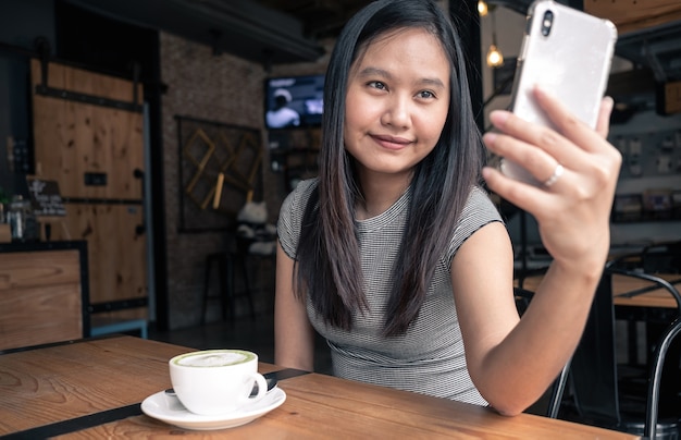 De vrouwen selfie beeld van Azië door haar smartphone in koffiewinkel