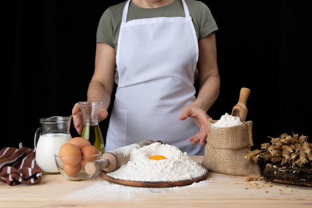 De vrouwenbakker bereidt gebakjes met recept voor