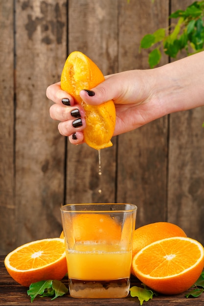 De vrouwenhand drukt dicht omhoog jus d'orange