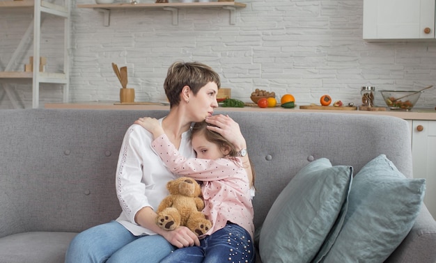 De ware liefde van een moeder en dochter Een sensueel portret van een lieve gelukkige moeder en dochter die zachtjes thuis op de bank omhelzen en glimlachen