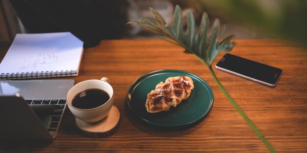De weergave-instelling van de cafétafel in het achtergrondconcept van de coffeeshop van een café- en restaurantbedrijfslevensstijl voor gebruik door de klant met eten en drinken