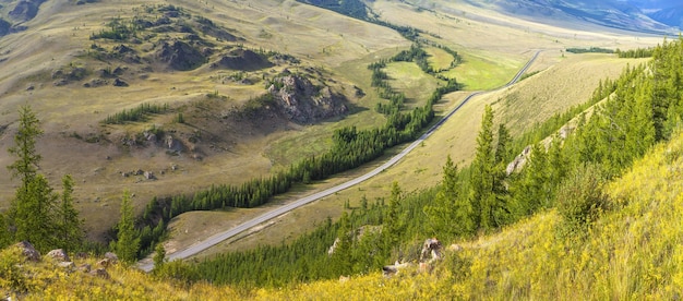 De weg loopt door een bergdal, panoramisch uitzicht