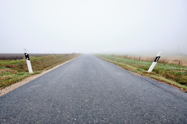 Foto de weg loopt door het landschap tegen een heldere lucht.