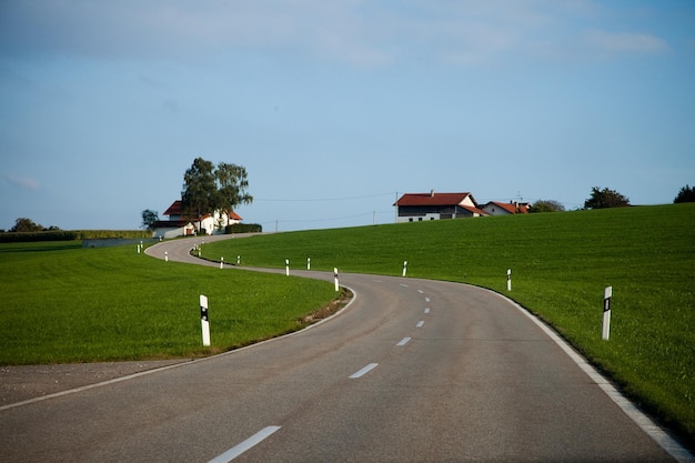 De weg midden in het gras tegen de lucht.